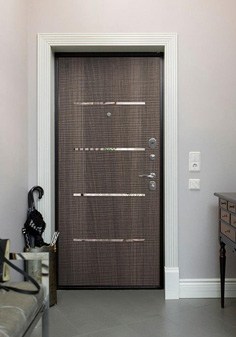 Входная дверь черного цвета в интерьере в классическом стиле, вид внутри со светлой отделкой