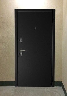 Входная дверь черного цвета в ярком интерьере, вид снаружи с темной отделкой